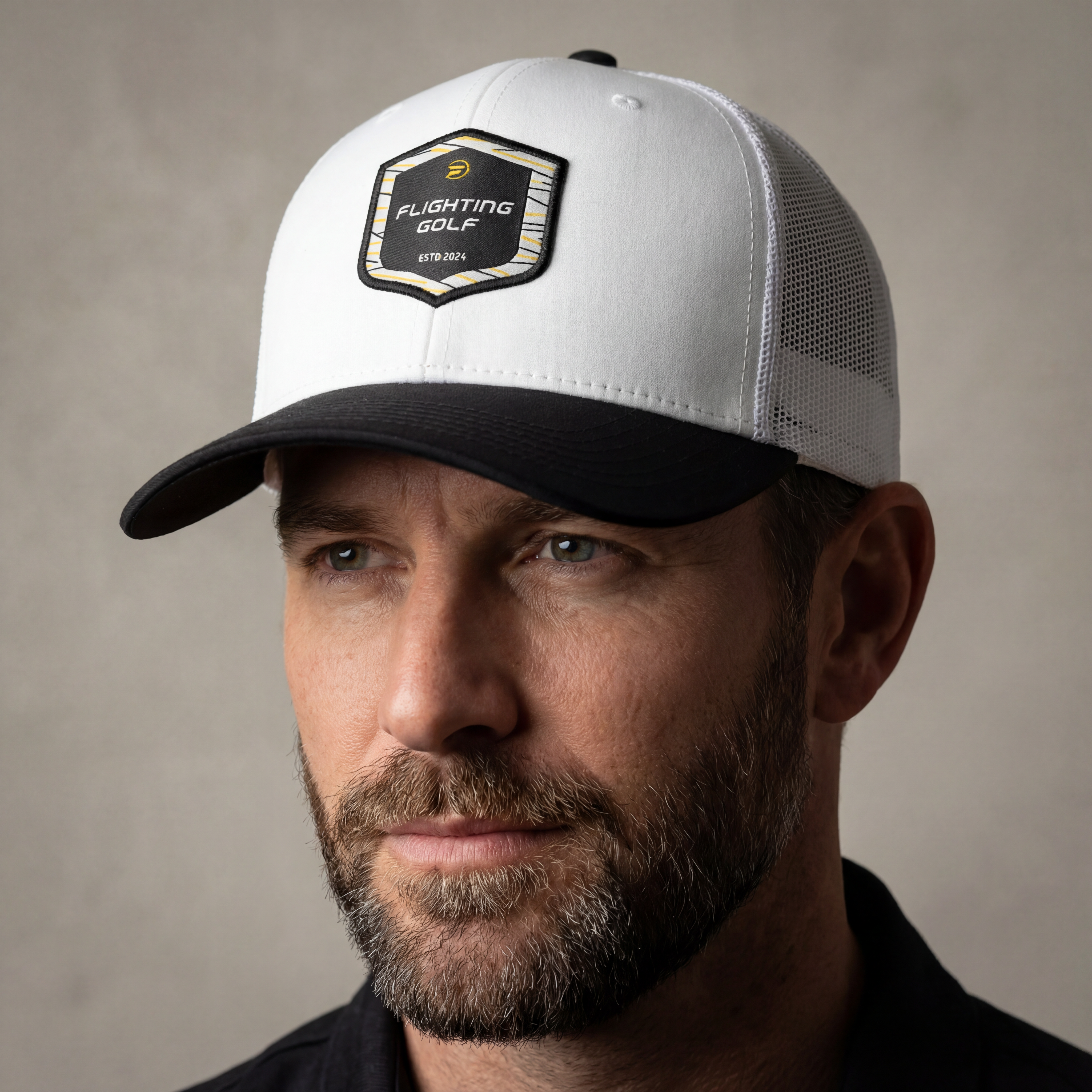 Man wearing a white and black cap with a brand logo on a neutral background